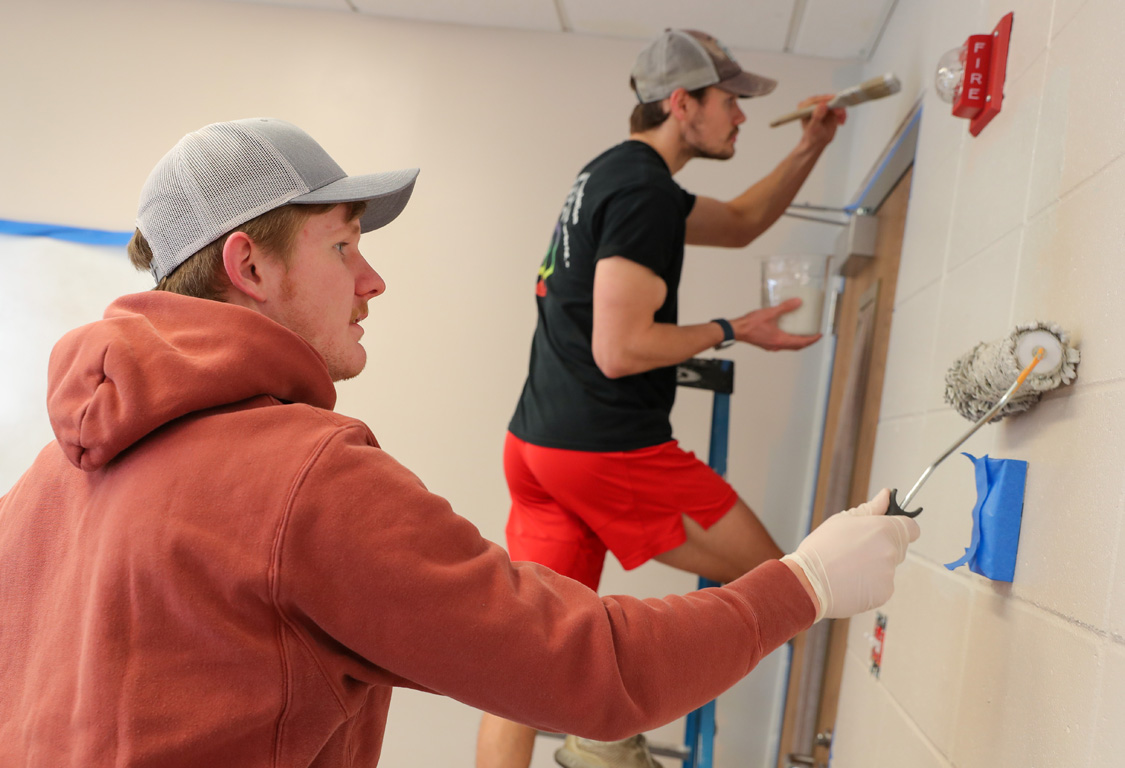 UNK students Austin Wells, front, and Blake Edzards paint a classroom inside Holy Cross Lutheran Church in Kearney during The Big Event.