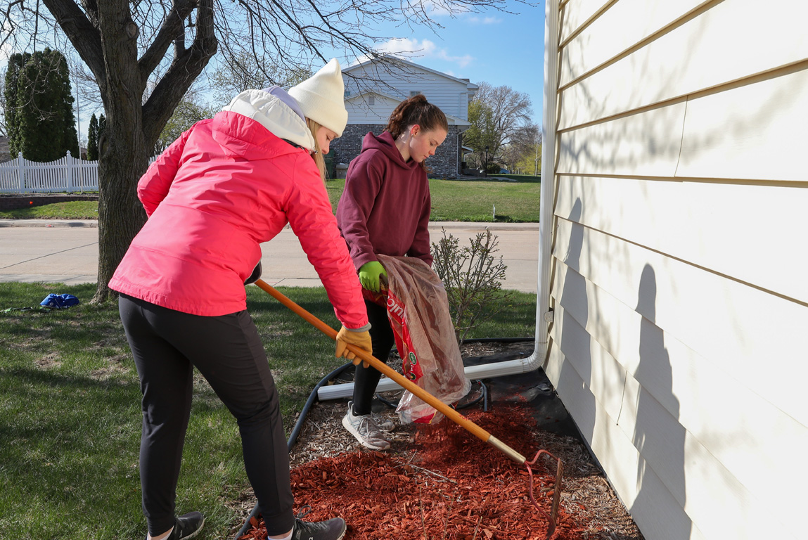 UNK students McKenzie Clark-Brownlow, front, and Mary Kasten spread mulch outside Holy Cross Lutheran Church’s Youth House on Saturday. The Exercise Science Club members participated in the community service project as part of The Big Event.