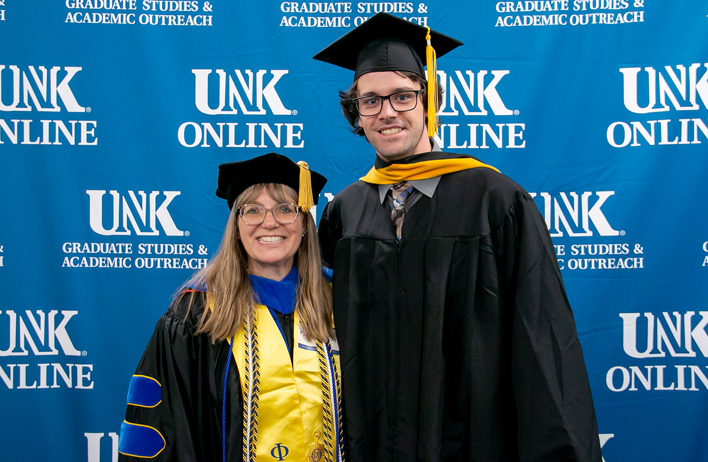 Blase Rokusek poses for a photo with UNK biology professor Kim Carlson during last week’s spring commencement ceremony. Rokusek earned a master’s degree in biology.