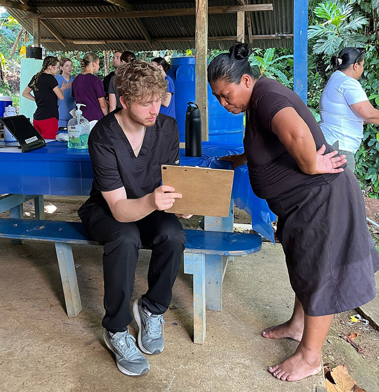 UNK spring graduate Trenten Theis works with a patient during a mobile medical clinic in Bocas del Toro, Panama.