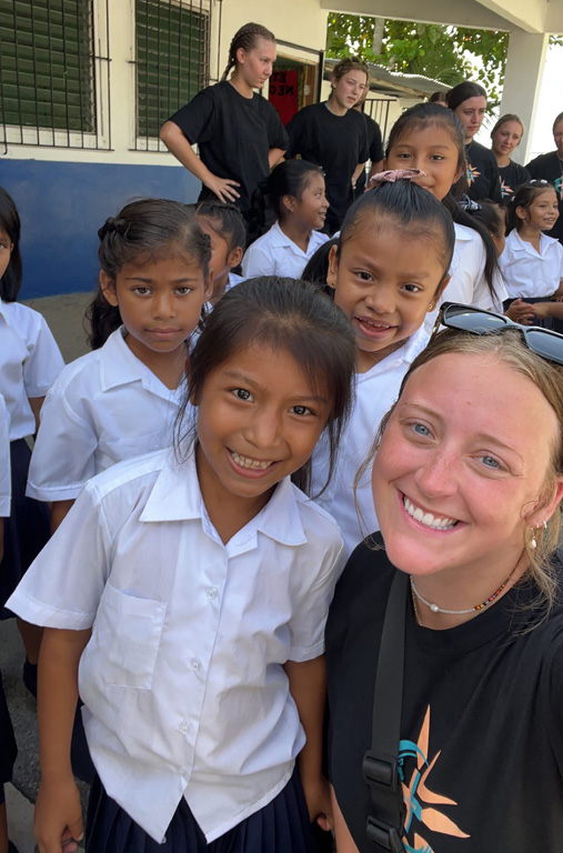 UNK junior Daylee Dey poses for a photo with students at a local school during a recent medical outreach trip to Panama.