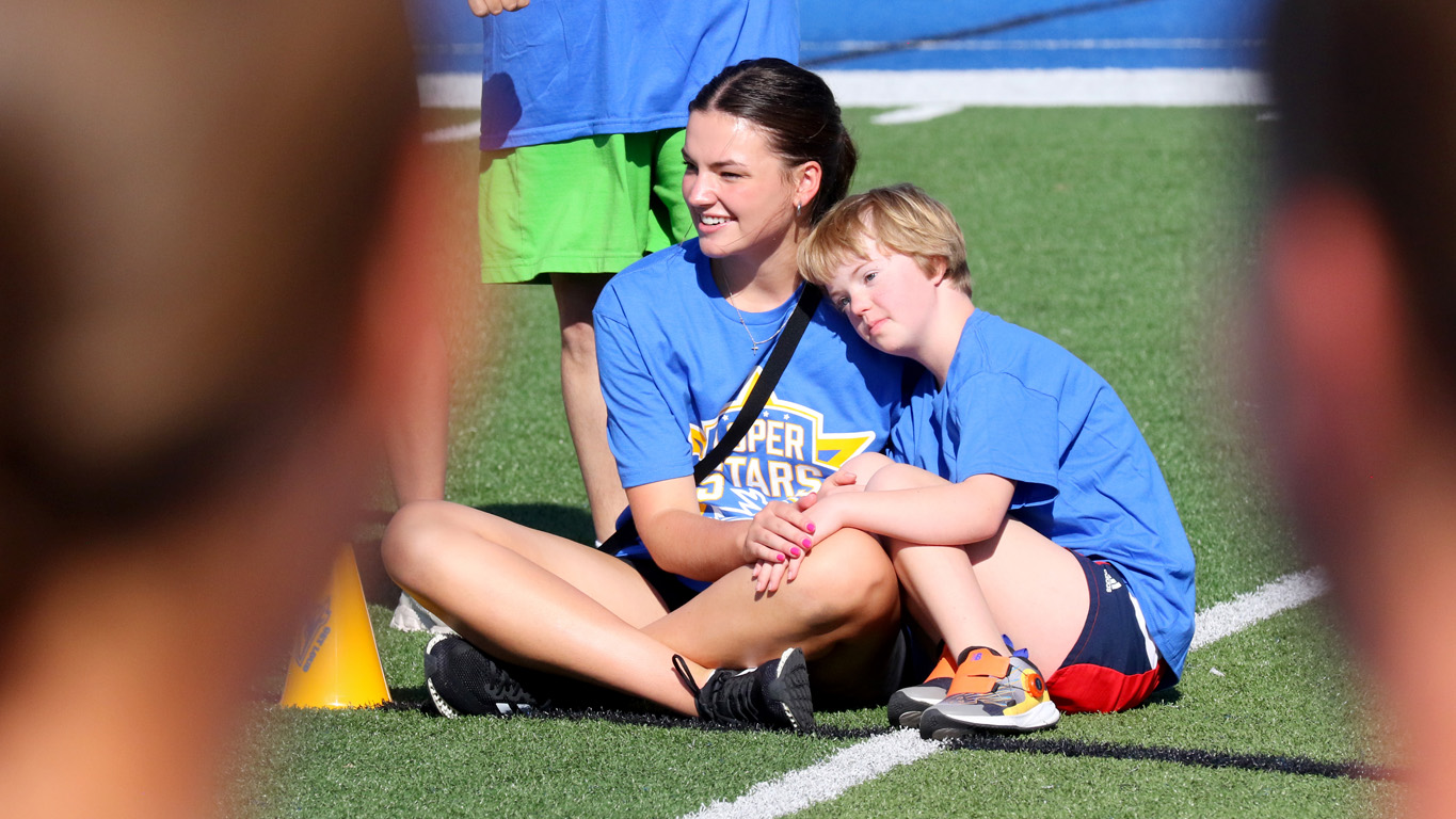 Harper Hopkins, right, and UNK basketball player Brinly Christensen watch the Pride of the Plains drum line perform during Sunday’s Loper Stars event at Cope Stadium. (Photos by Todd Gottula, UNK Communications)