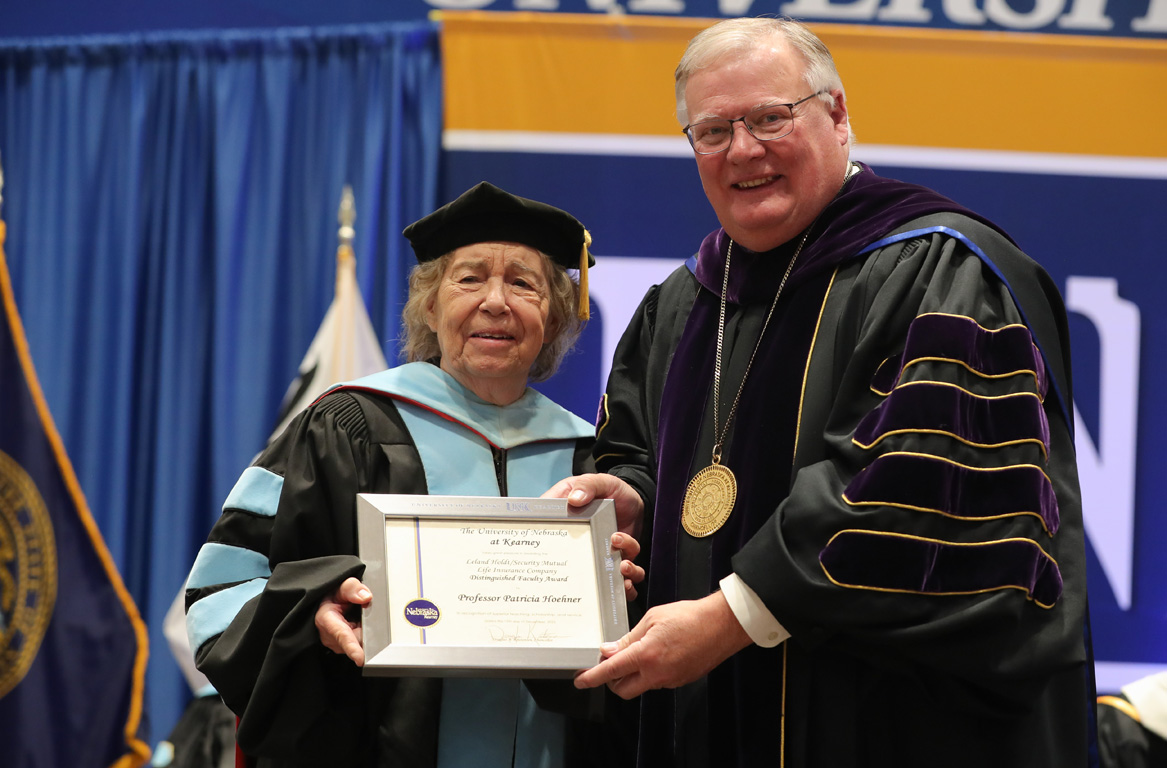 UNK Chancellor Doug Kristensen presents the Leland Holdt/Security Mutual Life Distinguished Faculty Award to professor Patricia Hoehner during Friday’s winter commencement ceremony at the Health and Sports Center on campus. (Photo by Erika Pritchard, UNK Communications)