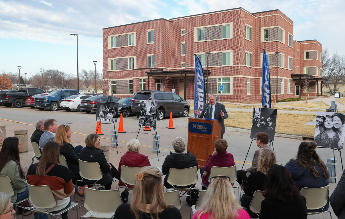 UNK Chancellor Doug Kristensen addresses the crowd during Thursday’s dedication ceremony for Bess Furman Armstrong Hall, pictured in the background.