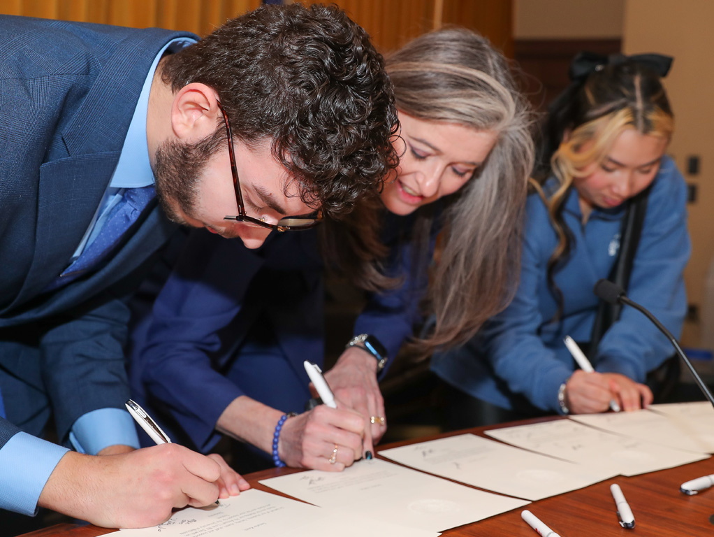 Student Body President Temo Molina and other UNK supporters sign thank-you notes for state senators Wednesday during the annual “I Love NU” Day event at the State Capitol.