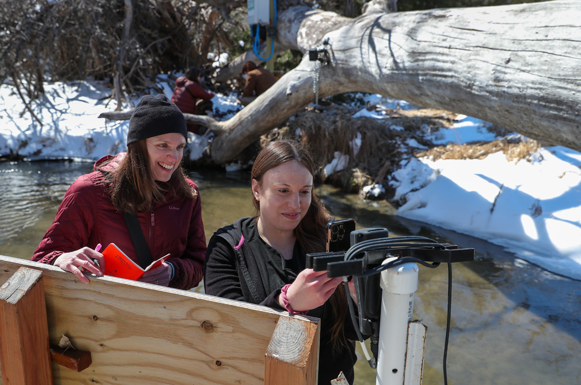 UNK professor Mary Harner, left, and research technician Jamila Bajelan measure water quality next to a GaugeCam at the Kearney Outdoor Learning Area. The work is part of the GRIME Lab research. (Photos by Erika Pritchard, UNK Communications)