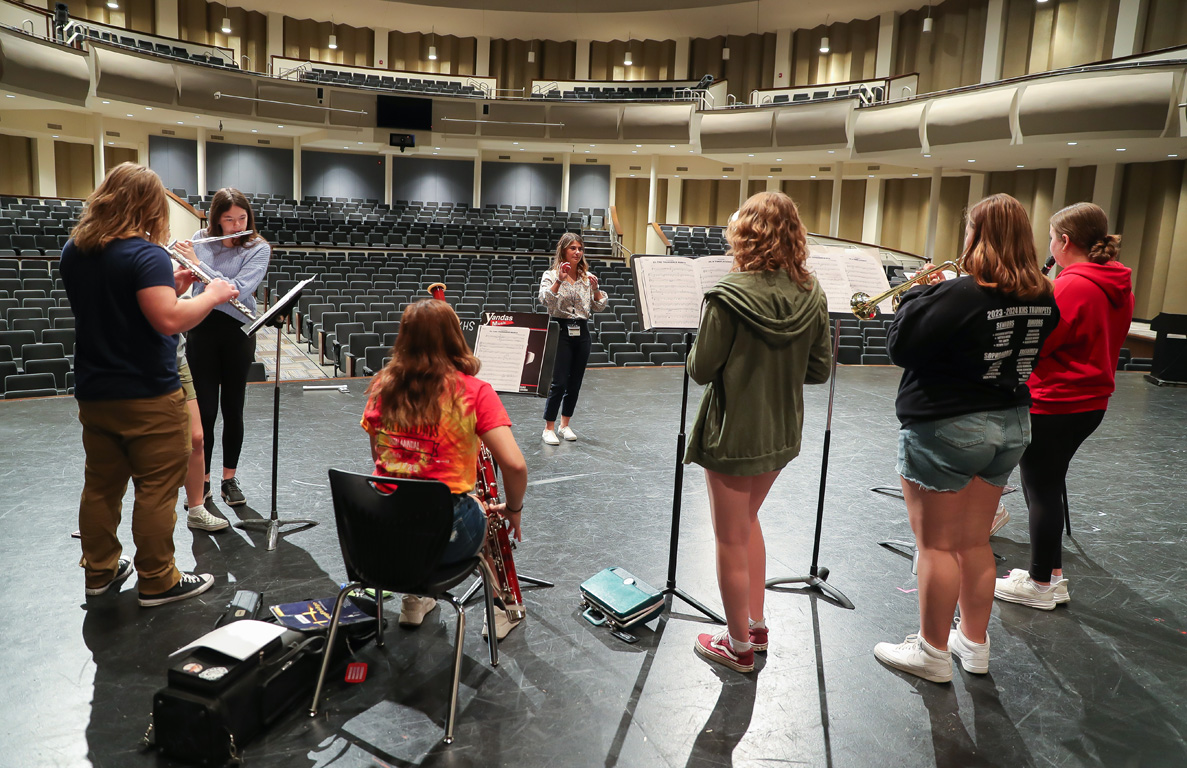 UNK senior Sadie Uhing works with students at Kearney High School, where she’ll be the new orchestra director this fall. (Photo by Erika Pritchard, UNK Communications)