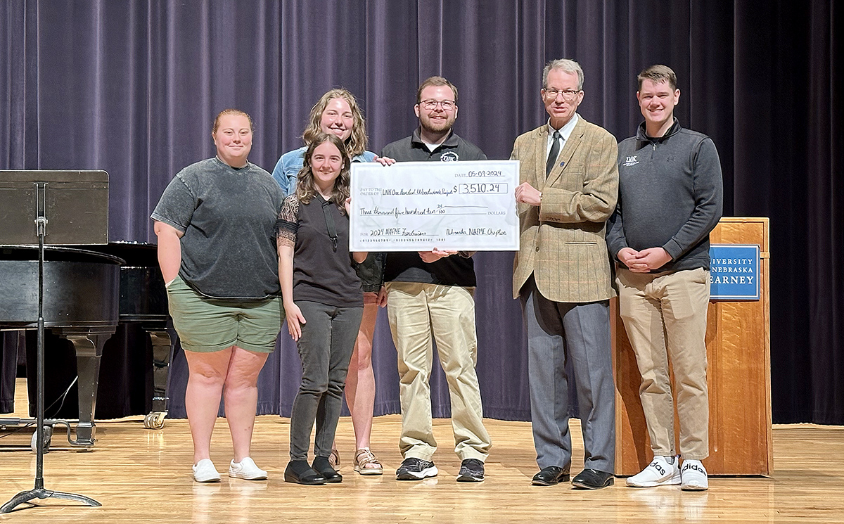 UNK music education students Madison Miller, Rebecca Hoffman, Emma Schroeder, Sam Heitz and Ryan Sims present a $3,500 check to music professor David Nabb in support of the One-Handed Woodwinds Program.