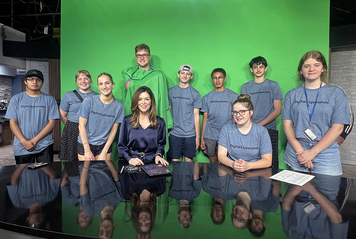 NTV news anchor Colleen Williams poses for a photo with students attending the Digital Expressions Media Camp.