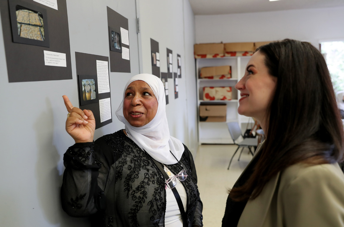 A woman who participated in the PhotoVoice project shares her immigration experience with UNK associate professor Tiffani Luethke, right.