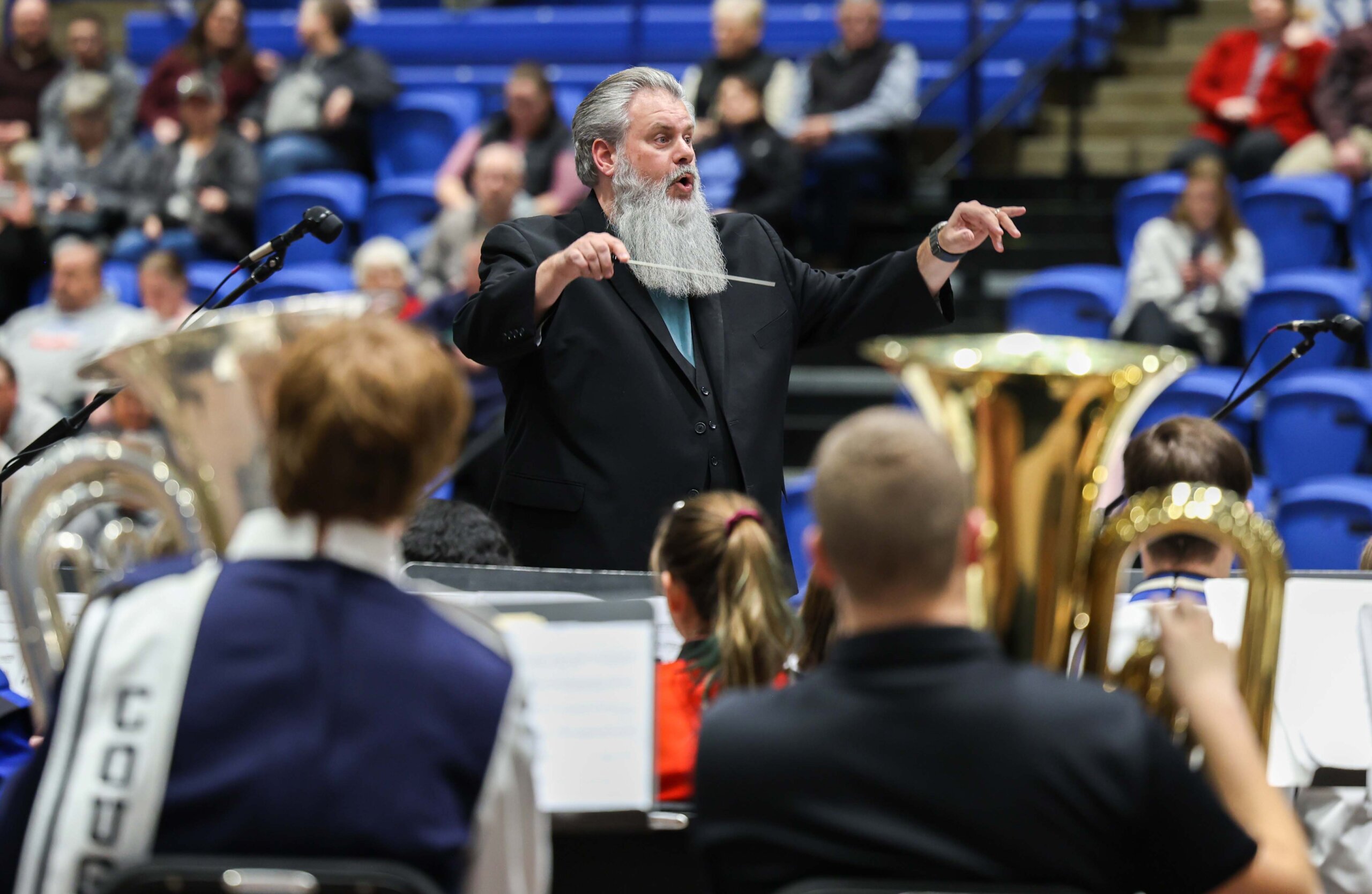 A conductor leads a high school band concert at UNK.