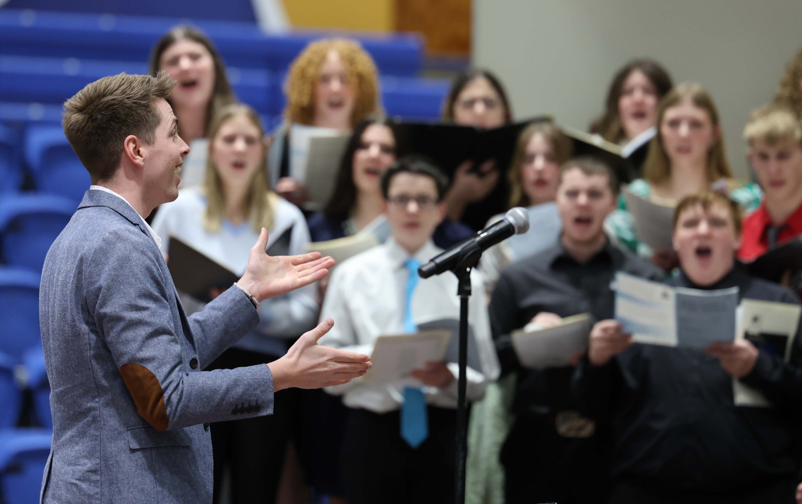 A conductor leads a choir of high schoolers at UNK.