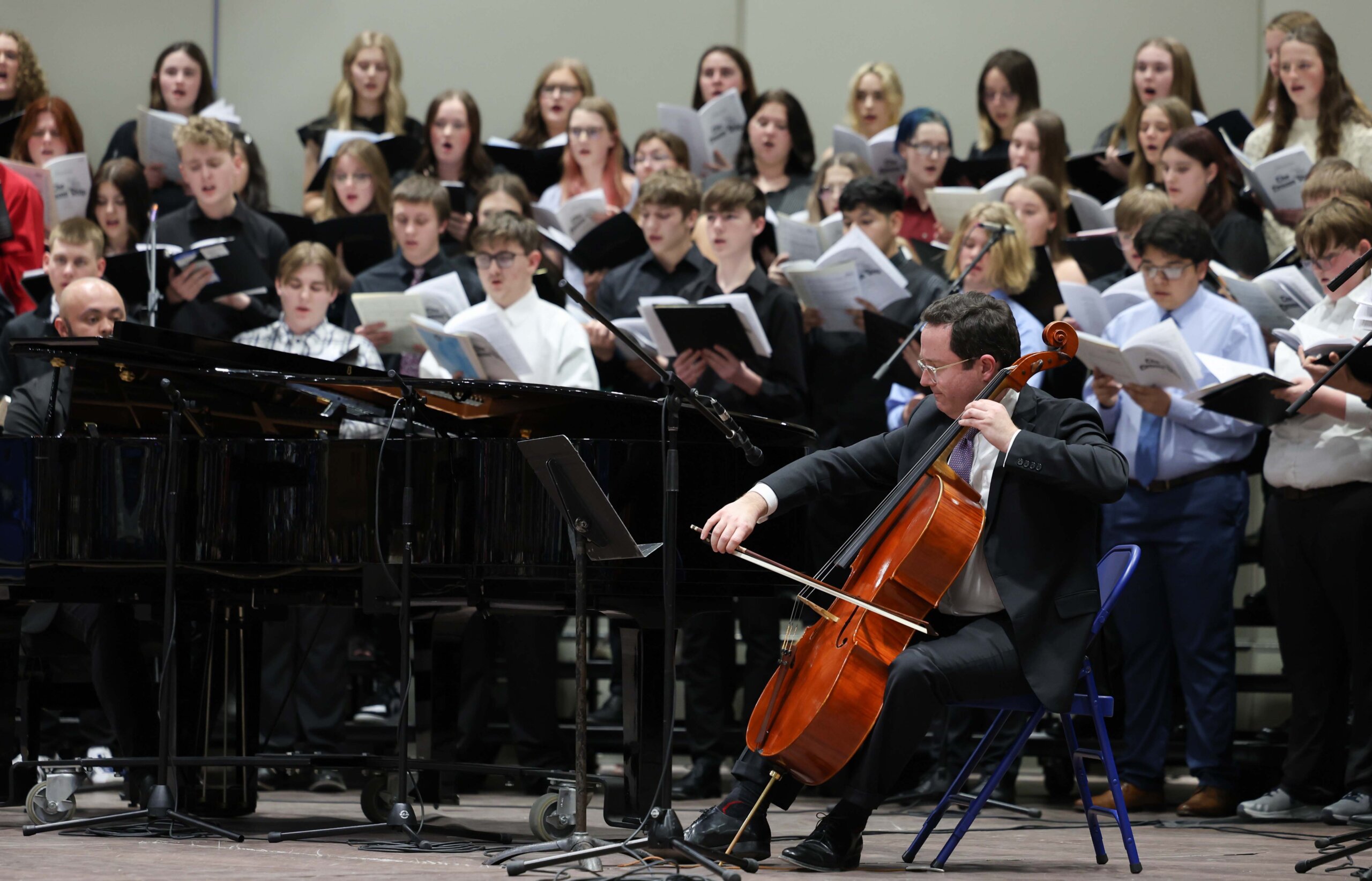 A pianist and violinist accompany a choir of high school students at a concert at UNK.