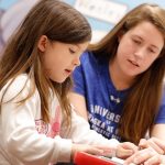UNK swimmer Mikara Feit, a junior from Lincoln, reads with a kindergartner during a recent visit to Kenwood Elementary School in Kearney. The UNK swimming and diving team is partnering with Kenwood Elementary through the new Loper AthLEADS program. (Photo by Corbey R. Dorsey, UNK Communications)