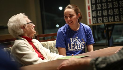 Kaitlyn Pineda, a UNK sophomore from Kearney, visits with Ellamae Moseley, a resident at the Central Nebraska Veterans Home in Kearney. Pineda and other members of the UNK Leads program stopped by the veterans home Wednesday evening to tour the facility and play bingo with residents. (Photo by Corbey R. Dorsey, UNK Communications)