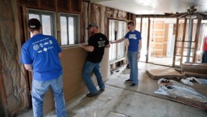 UNK students Jaden Powers of Central City, left, and Jacob Nutter of Geneva, right, put up drywall Saturday with Trevor Clark of Kearney inside a Gibbon home damaged by floods. The work was part of The Big Event, which included 500 UNK students who volunteered in Kearney and surrounding communities. (Photo by Corbey R. Dorsey, UNK Communications)