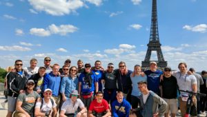 Members of the UNK wrestling program pose for a photo near the Eiffel Tower while visiting Paris, France. Loper wrestlers, coaches and alumni spent a day in Paris before flying to Athens, Greece, during last month’s international trip. (Courtesy photo)