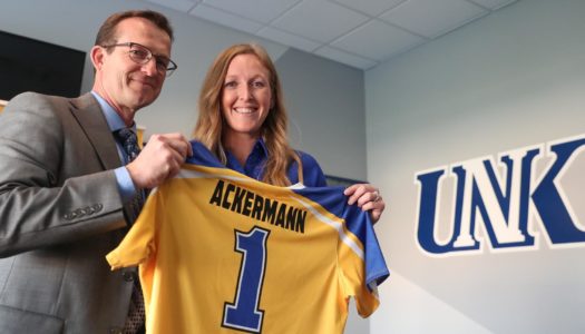 UNK Athletic Director Marc Bauer, left, presents a jersey to new Loper softball Head Coach Katie Ackermann at Wednesday night's news conference. (Photo by Corbey R. Dorsey, UNK Communications)