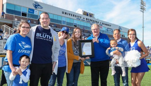 UNK Chancellor Doug Kristensen presents the Outstanding Family Award to Bill and Becky Williams of Kearney. Krista, far right, and Morganne, fifth from left, are current UNK students. Their oldest son Trevor and his wife Carly, far left, both graduated from UNK. (Photo by Corbey R. Dorsey, UNK Communications)