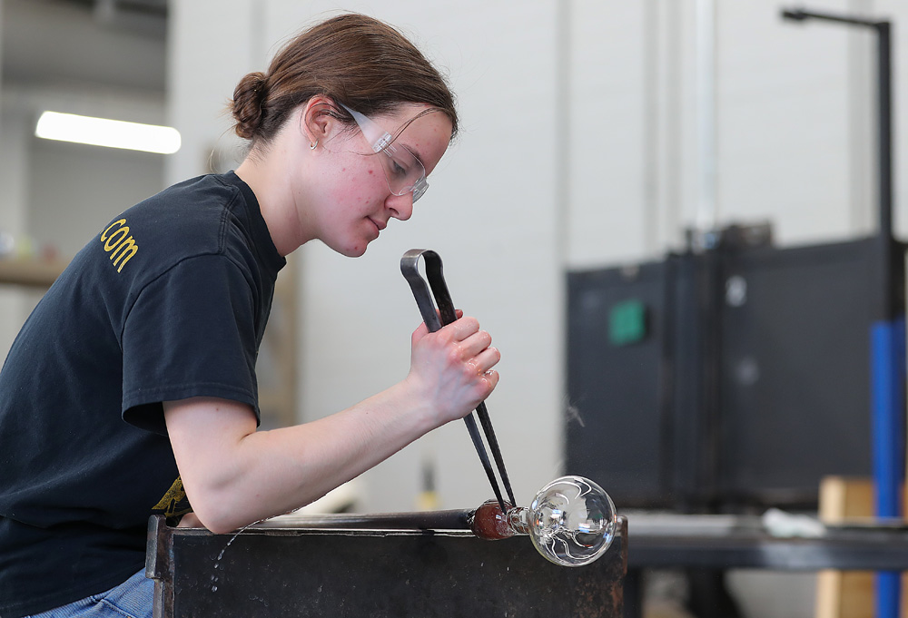 UNK sophomore Jackie Hinze creates a holiday ornament Tuesday inside the glass studio on campus. (Photos by Erika Pritchard, UNK Communications)