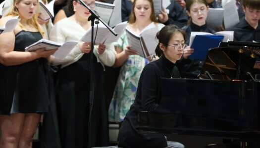 A pianist accompanies a choral performance at UNK.