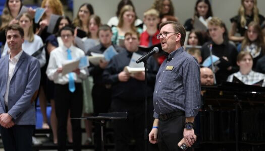 A music professor speaks at a choral concert at UNK.