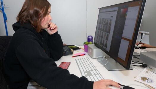A student works on the newspaper on her computer.