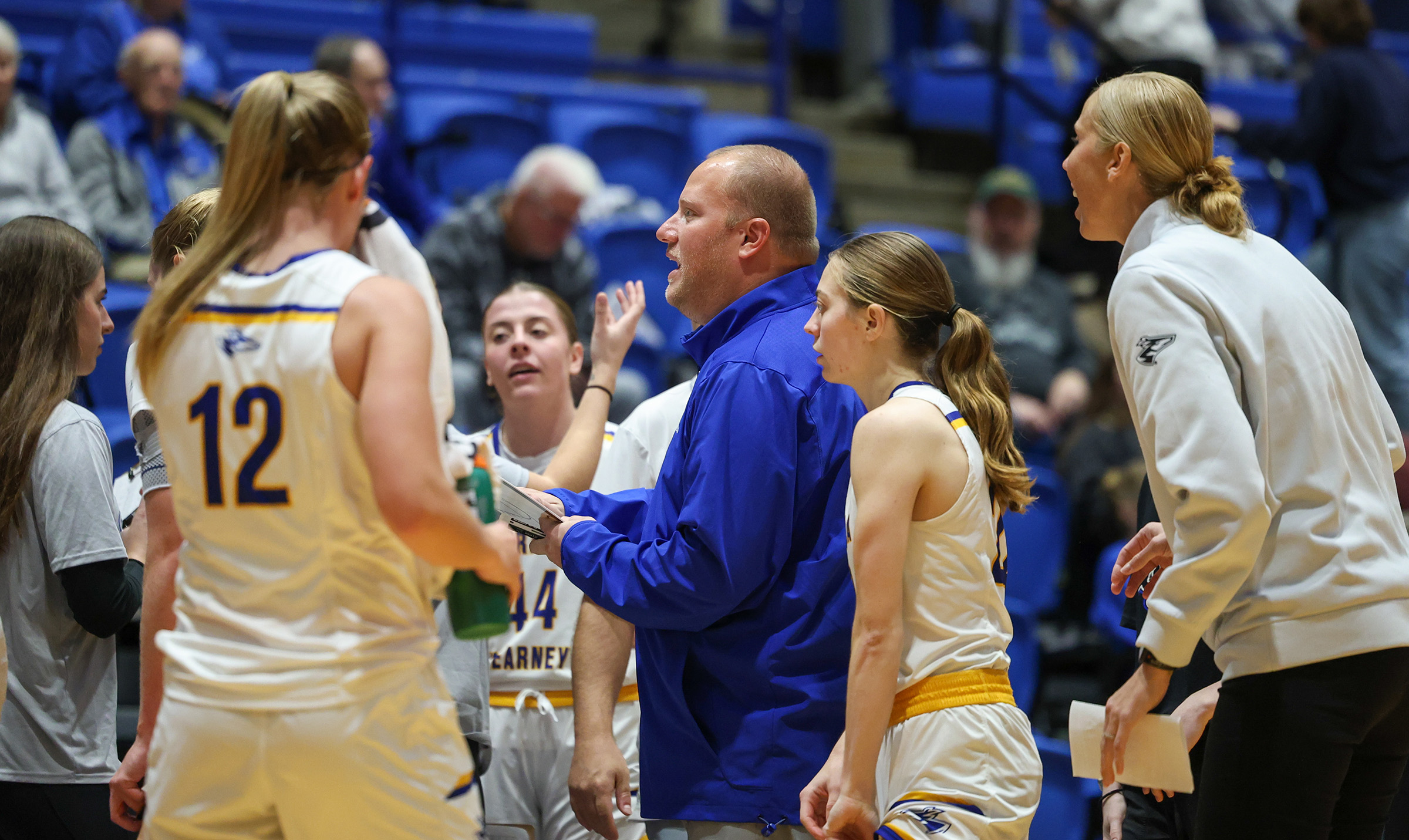 UNK coaches Drew and Nicole Johnson lead a team huddle during a game at the Health and Sports Center.