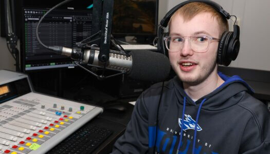 A student speaks into a microphone at the student radio station.