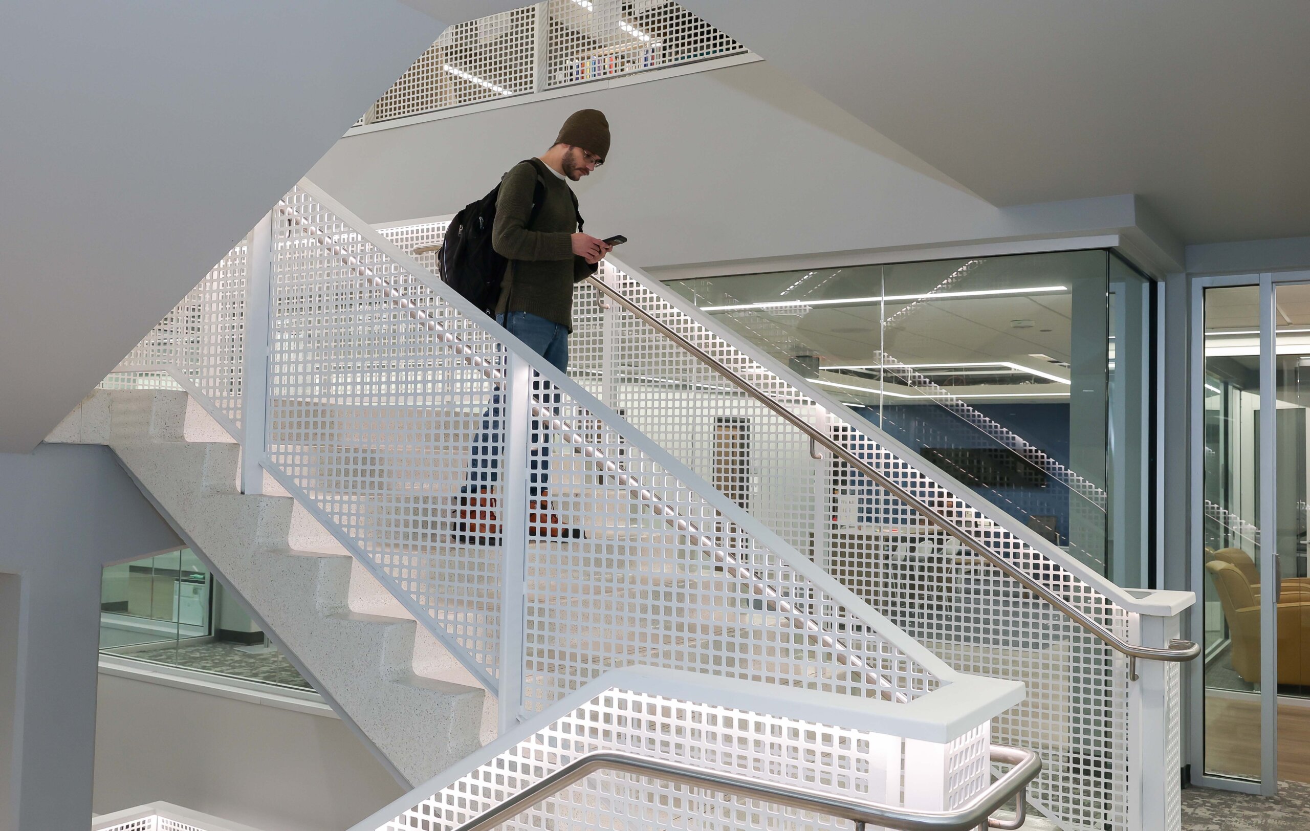A student walks down a stairwell.