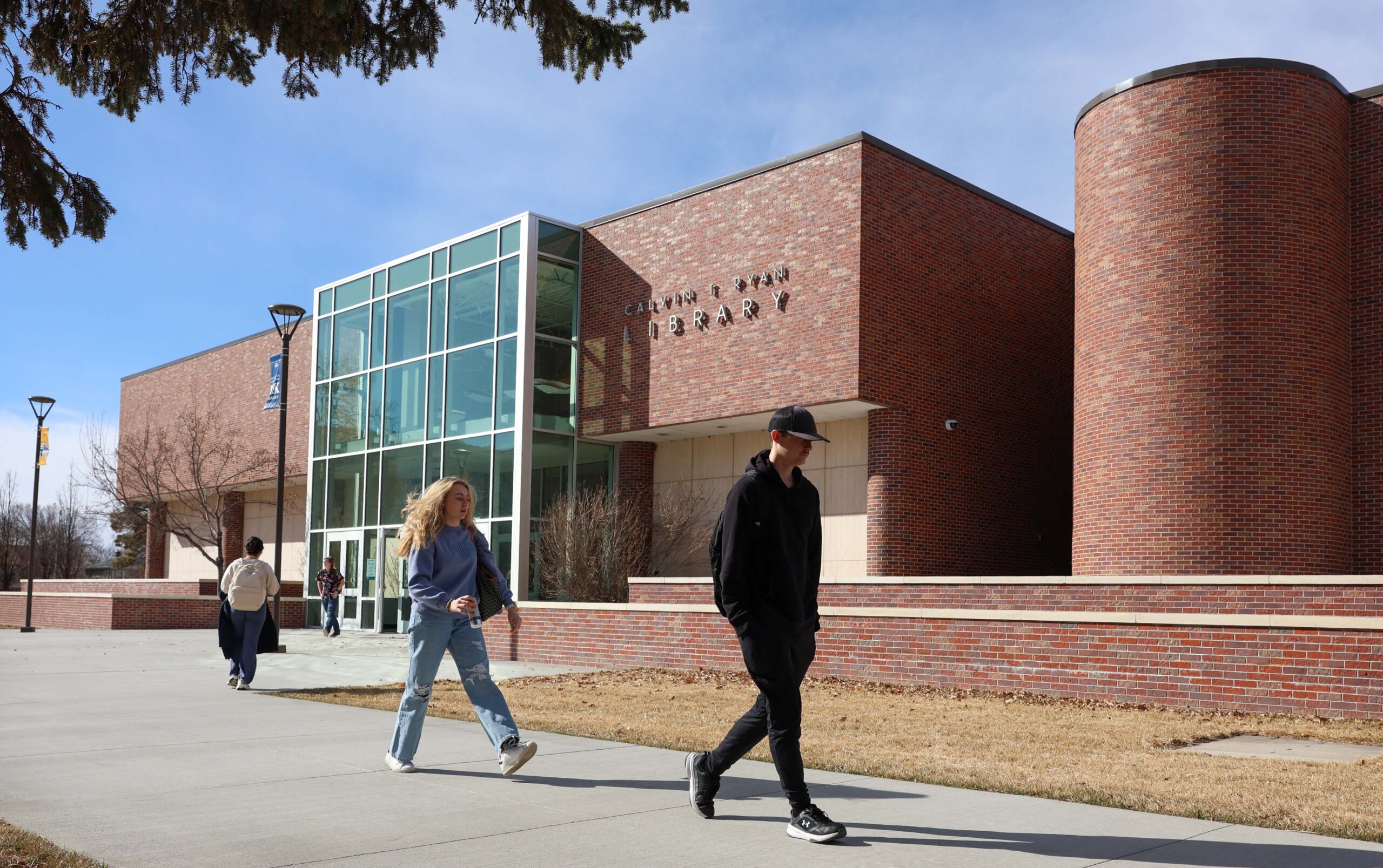 Students walk past the exterior of the Calvin T. Ryan Library.
