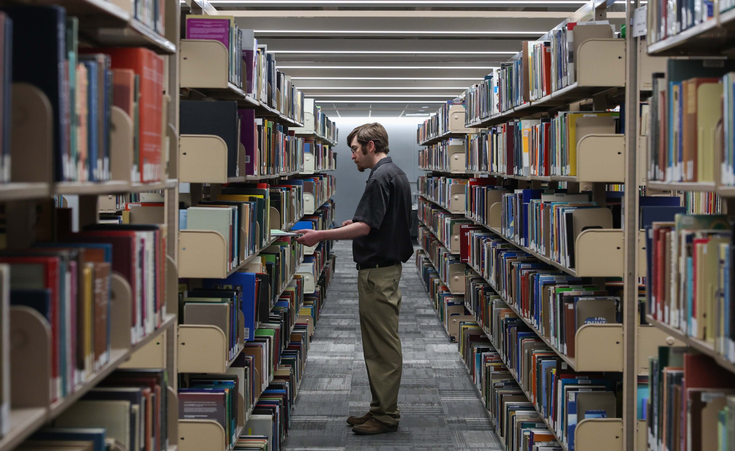 A man takes inventory of library books.