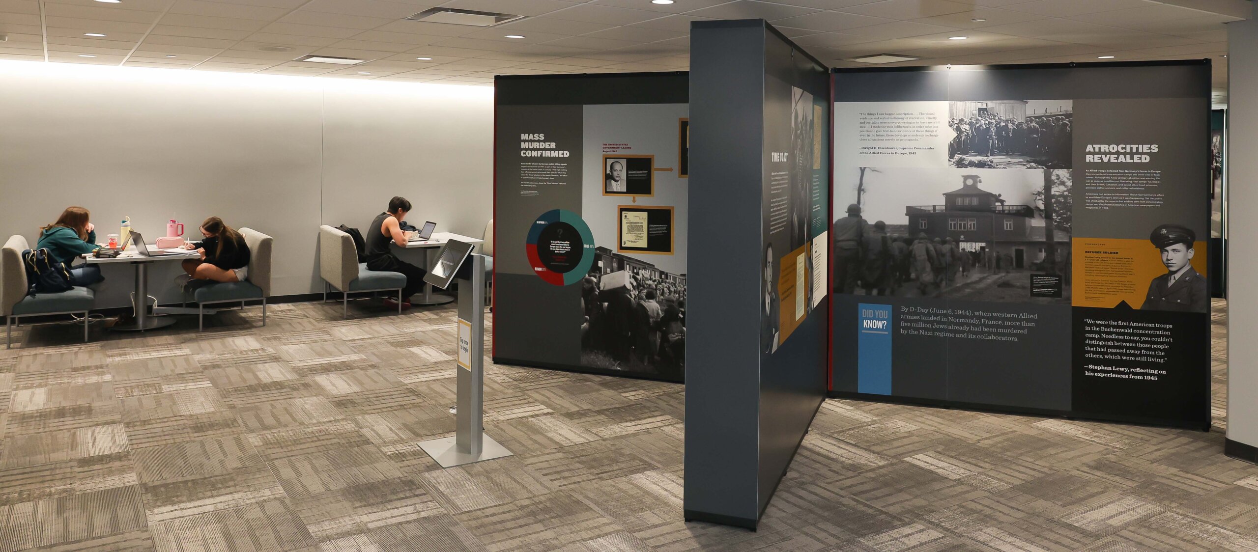Students study in the library next to a Holocaust remembrance display.