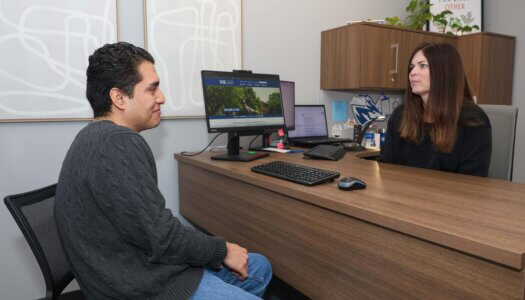 A woman advises a student in her office.