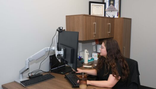 A woman works on a computer in her office.