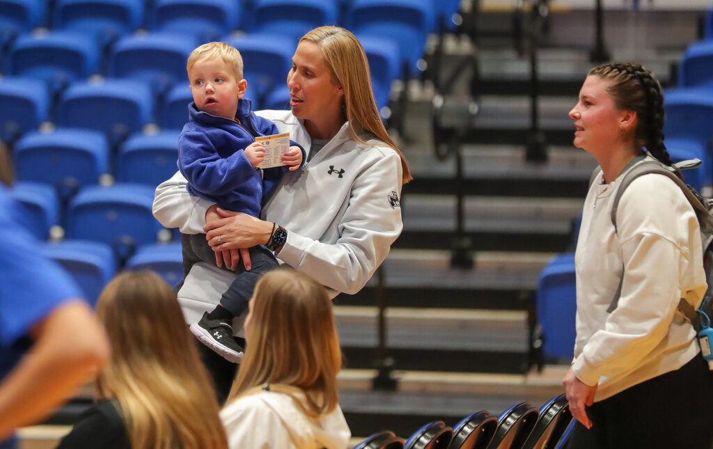 Nicole Johnson holds her youngest son inside UNK's Health and Sports Center.