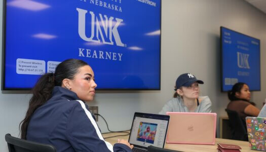 Students listen to a presentation in a classroom.