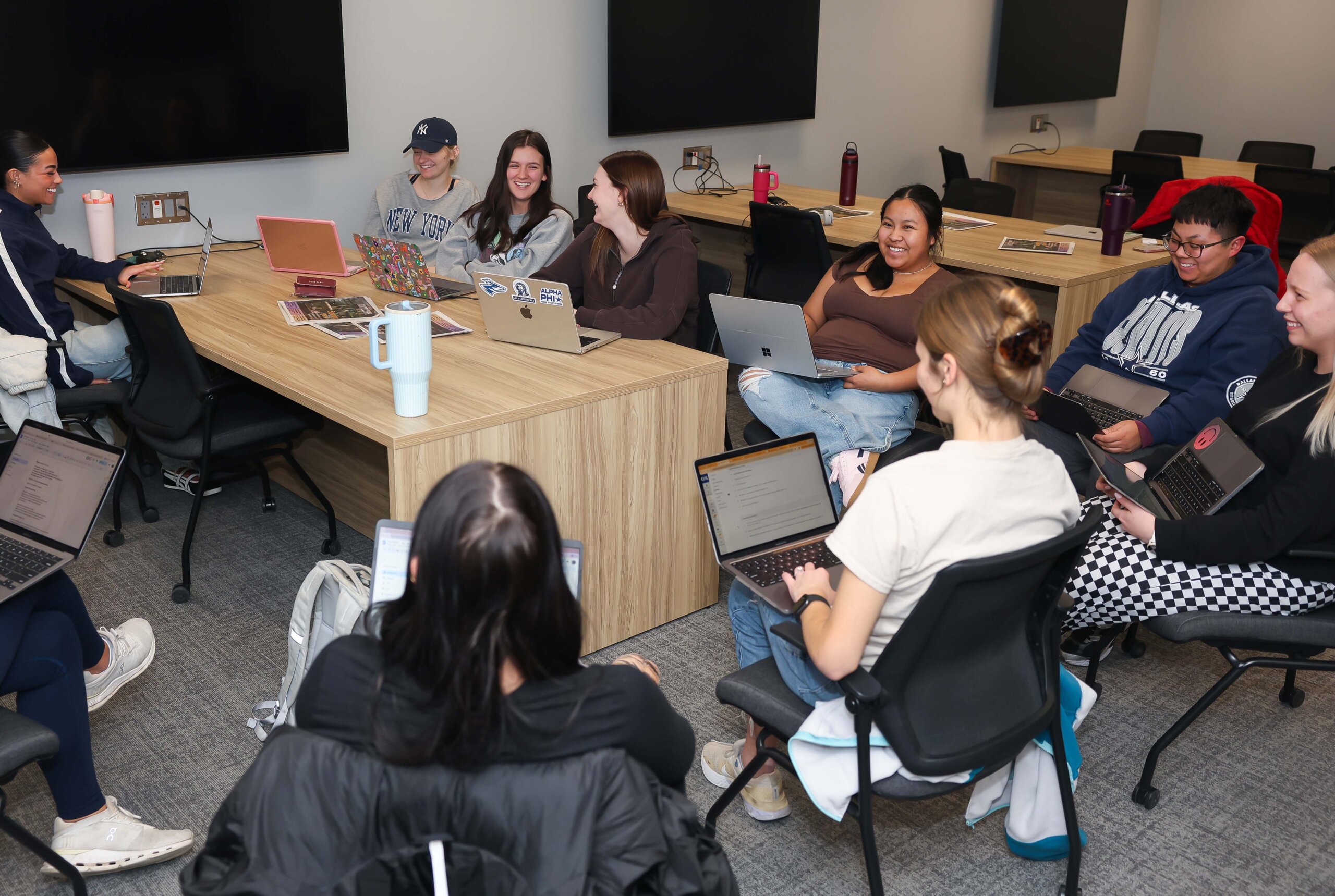 Students huddle on a group project in a classroom.