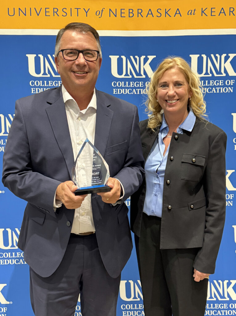 Brian Kort holds his award while posing for a photo with his wife Shelly.
