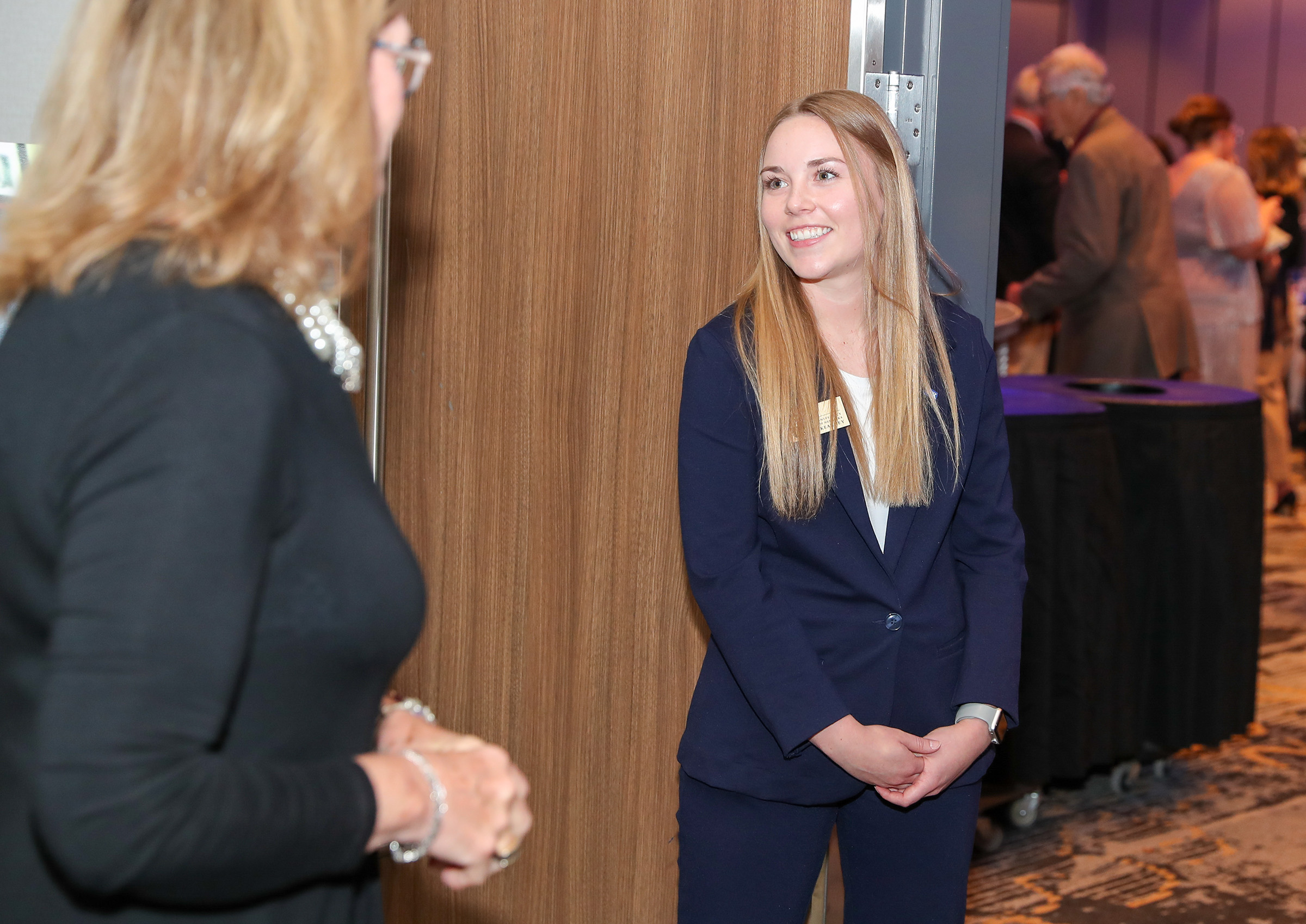 A UNK Chancellor's Ambassador greets guests during former Chancellor Doug Kristensen's retirement party.