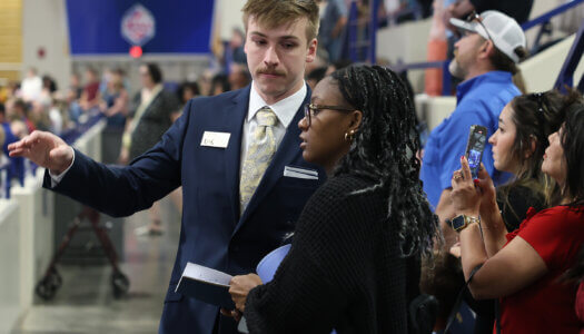 Chancellor's Ambassador John Placke assists during a UNK commencement ceremony.