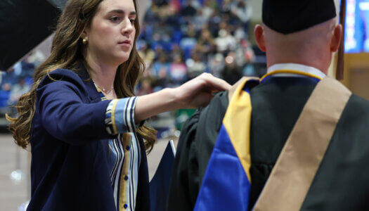 Chancellor's Ambassador Emma Nolan assists during a UNK commencement ceremony.