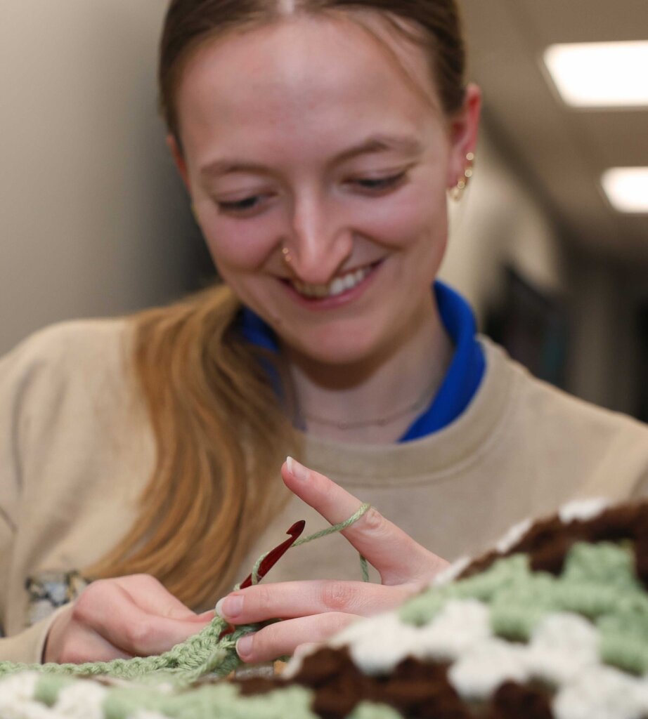 A Crochet Circle member works on a blanket during a recent meeting.
