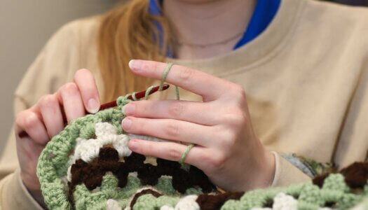 A Crochet Circle member works on a blanket during a recent meeting.