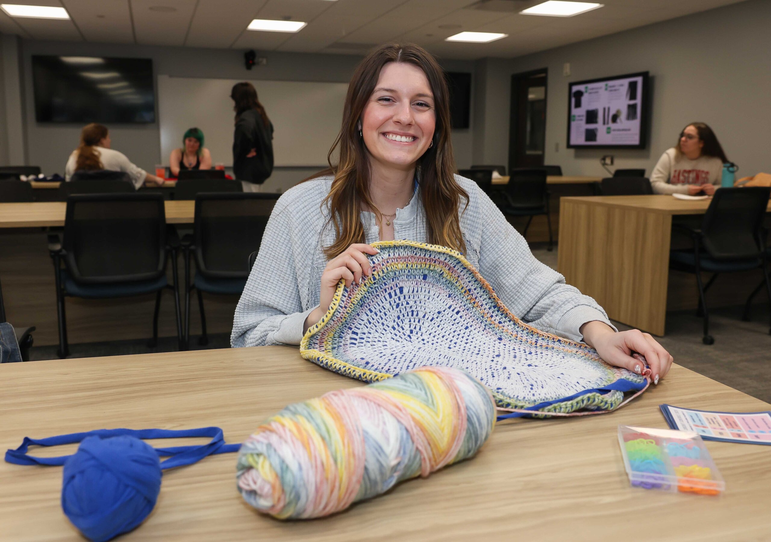 UNK student Laura Carnahan poses for a photo with a project she's working on during Crochet Circle.