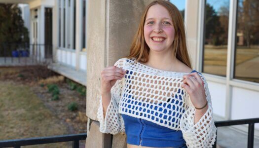 A Crochet Circle member poses for a photo with one of her projects.