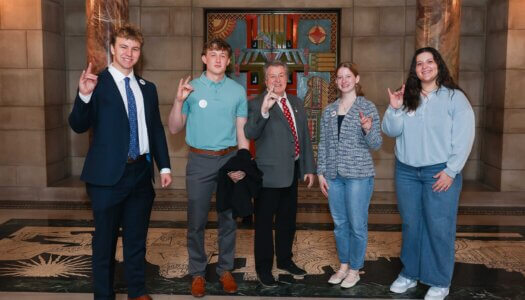Sen. Stan Clouse poses for a photo with UNK students in the State Capitol Rotunda.