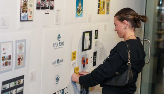 A UNK student displays her recognition during the Faculty Select Exhibit reception.