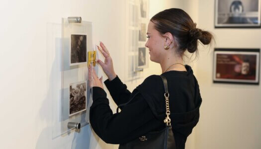 A UNK student displays her recognition during the Faculty Select Exhibit reception.