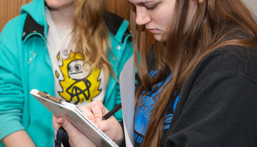A student takes notes during a staged crime scene investigation.
